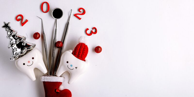 Dental-themed Christmas decoration with tooth characters, tools, ornaments, and "2023" numbers on white background.