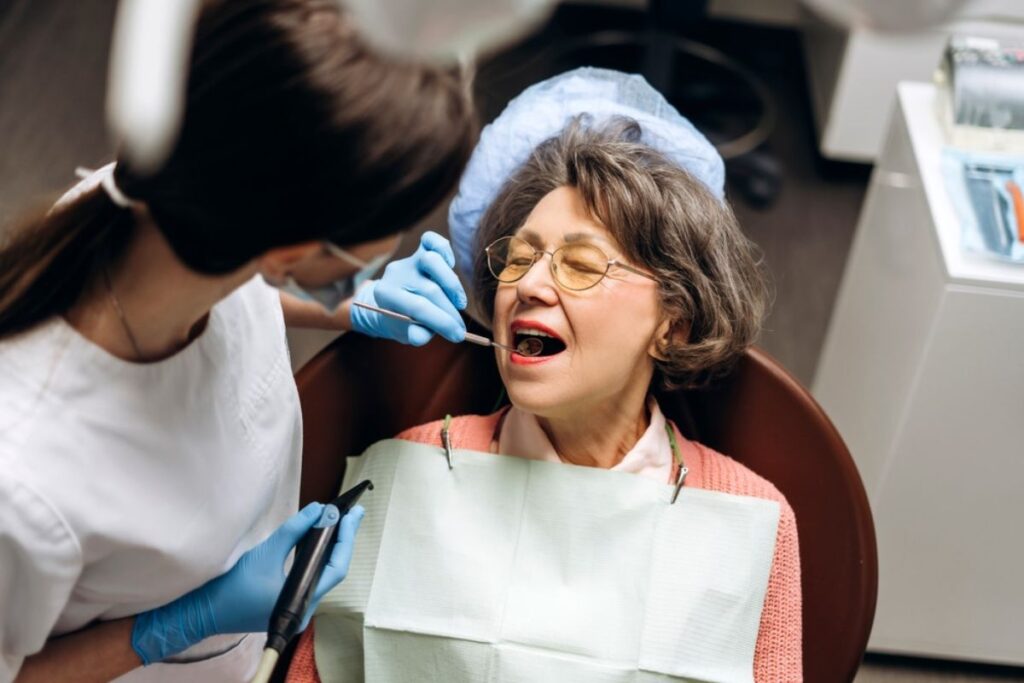A dentist examining a patient's teeth, highlighting the connection between oral health and overall well-being.