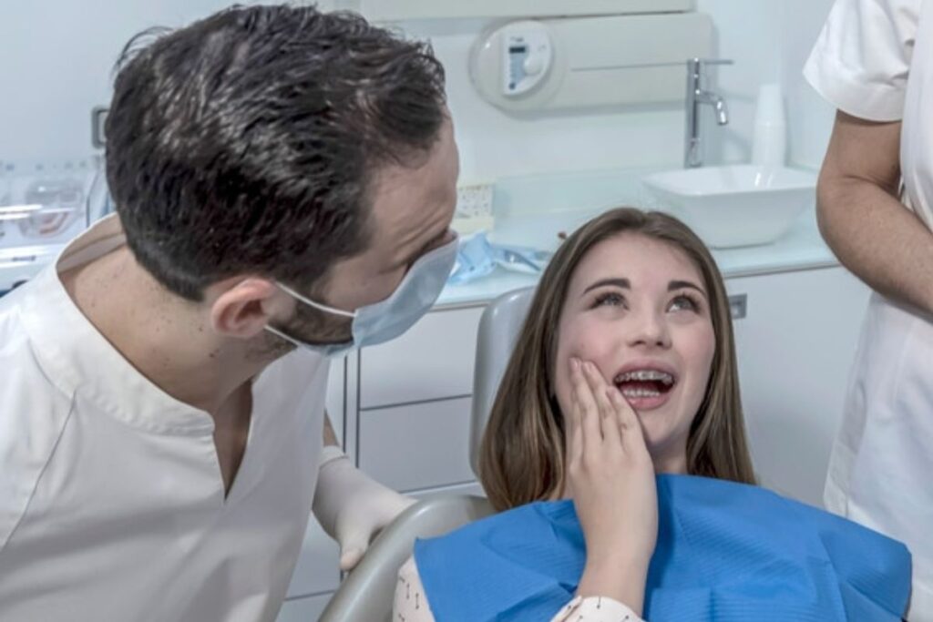 Person with tooth pain holding jaw, seeking dental care in Derry, NH.